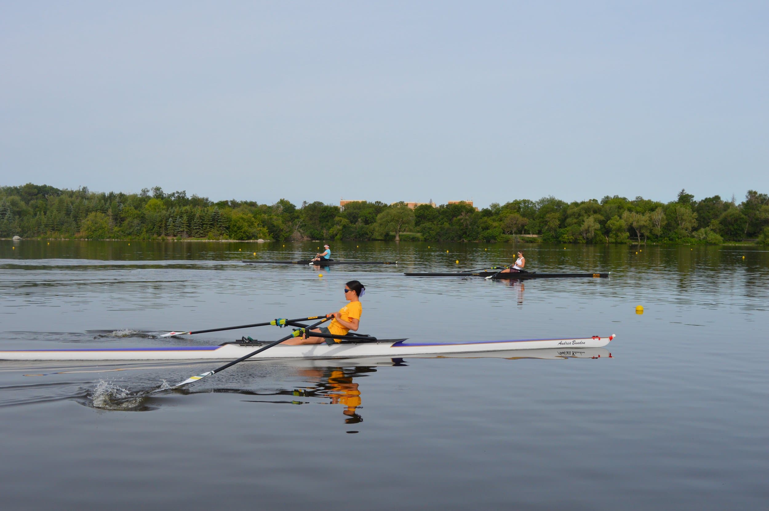 Three rowers on the water